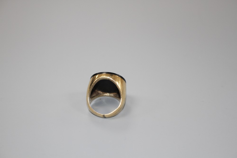 A yellow metal (stamped 9ct) and black onyx set circular signet ring, size L, gross weight 9 grams.